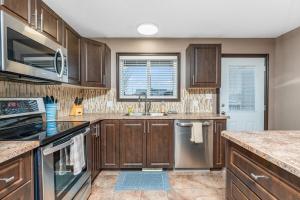 a kitchen with wooden cabinets and stainless steel appliances at Executive 5 bdrm 3 ba House in Bonnyville