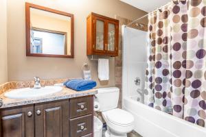 a bathroom with a sink and a toilet and a shower at Executive 5 bdrm 3 ba House in Bonnyville +8 photos