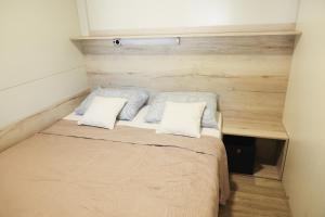 a small bedroom with a bed with two pillows at Mobile Home ADRIA in Privlaka