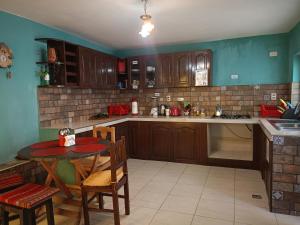 a kitchen with wooden cabinets and a small table with chairs at Spanish Friends in Sucre