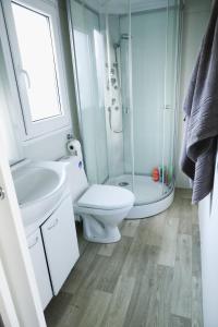 a bathroom with a shower and a toilet and a sink at Mobile Home ADRIA in Privlaka