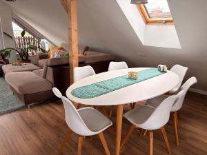 a dining room with a white table and chairs at Balaton Breeze in Balatonalmádi
