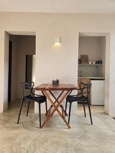 a wooden table and two chairs in a room at Statera Host - Pousada de Bem-Estar in Alto Paraíso de Goiás