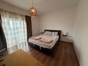 a bedroom with a bed and a large window at Balaton Breeze in Balatonalmádi