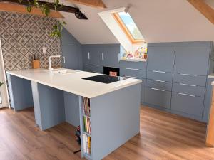 a kitchen with a white island and blue cabinets at Balaton Breeze in Balatonalmádi +13 photos