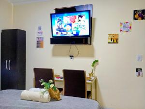 a room with a table and a tv on the wall at Capim de Ouro Flats Mobiliados in Palmas +23 photos