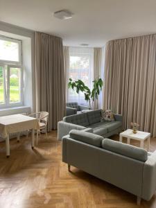a living room with two couches and a table at Hotel Zámeček na Čeladné in Čeladná