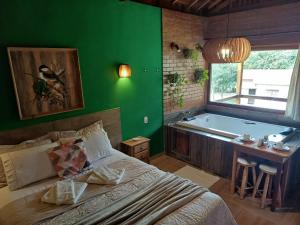 a bedroom with a bed and a bath tub at Pousada Recanto Lajinha - Chalé Amor Eterno in Visconde De Maua