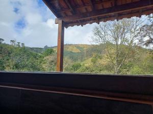 a window with a view of a mountain view at Pousada Recanto Lajinha - Chalé Amor Eterno in Visconde De Maua