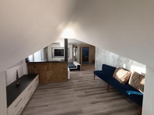 a living room with a blue couch and a kitchen at Proprietate privata in Lazu