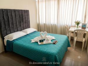 a hotel room with a bed with towels and a table at MiHOSTAL ELIAS in Tacna