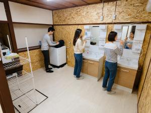 a group of people standing in a bathroom at ゲストハウス元町 in Ise