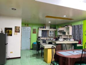 a kitchen with green walls and a table and chairs at Maeganbeverly's Place in Santa Fe