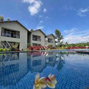 a large swimming pool in front of a building at The Fox Resort, Bandipur in Bandipūr