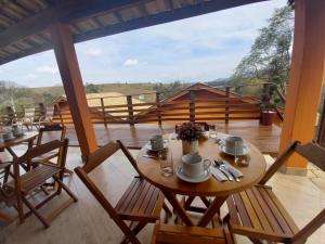 a table and chairs on a balcony with a view at Pousada Vale Verde com café da manhã in Lindóia