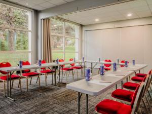 a conference room with tables and red chairs at Mercure Annecy Sud in Annecy +124 photos