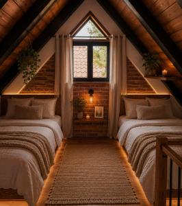 two beds in a attic room with a window at Cielito Querido in Mineral del Chico