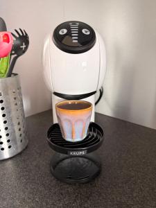 a coffee maker on a counter with a cup of coffee at Perla di Lago Maggiore in Oggebbio