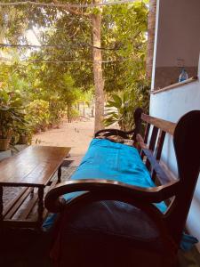 a bench sitting on a porch with a table at KR Villa in Arugam Bay
