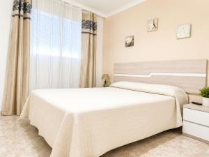 a white bedroom with a large bed and a window at LyriosHomes Beach Costa Ballena in Chipiona