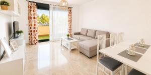 a living room with a couch and a table at LyriosHomes Beach Costa Ballena in Chipiona +4 photos