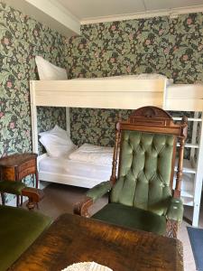 a bedroom with two bunk beds and a chair at Jugend 1902 in Ålesund