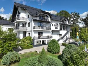 a large white building with a garden in front of it at Casa YDA in Horezu