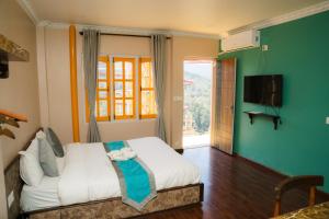 a bedroom with a bed and a television in it at Nagarkot Zip Coaster Pvt Ltd in Nagarkot