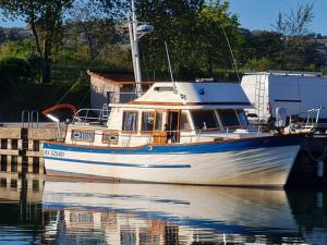 a white boat is docked in the water at Nuit de quiétude sur un bateau et dans l'eau in Condrieu +7 photos