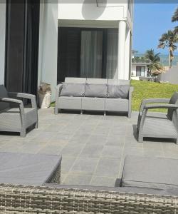 a patio with two chairs and a couch on a house at Waterfront Accommodations Villa 3B in Bijilo