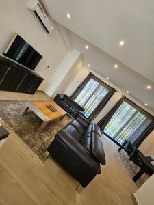 a living room with a leather couch and a table at Waterfront Accommodations Villa 3B in Bijilo