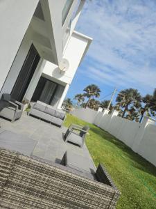 a white house with a patio and a lawn at Waterfront Accommodations Villa 3B in Bijilo