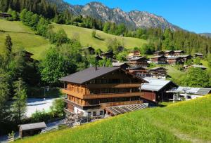 a village on a hill with a river and houses at Appartements Liftstüberl in Alpbach