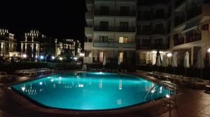 ein großes Schwimmbad vor einem Gebäude bei Nacht in der Unterkunft Summer Breeze Apartments in Sonnenstrand + 16 Fotos