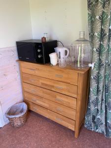 a microwave sitting on top of a wooden dresser at Örkelljunga cottage in Orkelljunga