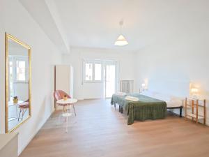 a white room with a bed and a mirror at Dimora Leccese in Lecce