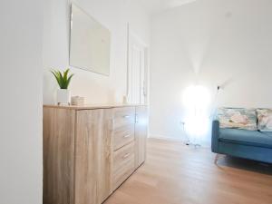 a living room with a wooden cabinet and a blue couch at Dimora Leccese in Lecce