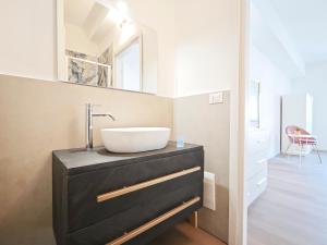 a bathroom with a sink on a black dresser at Dimora Leccese in Lecce