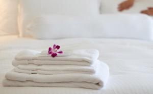 a pile of towels sitting on top of a bed at Mayflower Motel Milford in Milford
