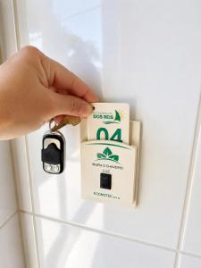 a person is unlocking a box on a wall at ApartPousada Residencial dos Reis in São Francisco do Sul