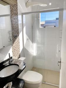 a bathroom with a sink and a toilet and a shower at ApartPousada Residencial dos Reis in São Francisco do Sul