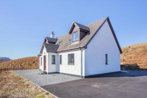 a white house with a roof on a hill at 3 Bed in Strathkanaird oc-r30948 in Ullapool