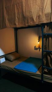 a bunk bed in a room with a blue mattress at Waves & Paws Hostel in Arugam Bay
