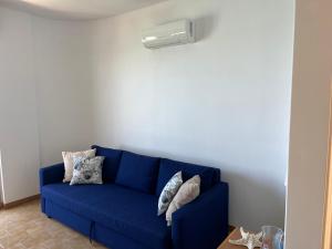 a blue couch with pillows on it in a room at La terrazza sul mare, 44 in Marzamemi +54 photos