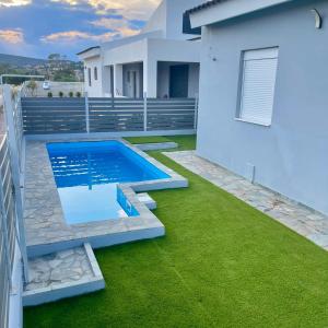 a backyard with a swimming pool and green grass at Casa Anavyssos in Anavyssos