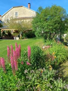 a garden with pink flowers in front of a house at Zelda in Roôcourt-la-Côte