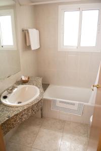 y baño blanco con lavabo, bañera y lavamanos. en Hotel Sorrabona, en Pineda de Mar