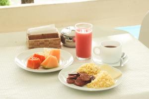 a table with two plates of breakfast food and a cup of coffee at Pousada Nossa Natal in Natal