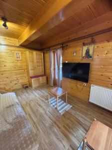 a room with a flat screen tv in a wooden wall at Apartman Tri srca Zlatar in Nova Varoš