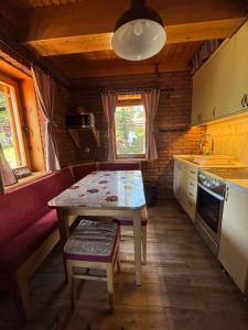 a kitchen with a table and a table and a bench at Apartman Tri srca Zlatar in Nova Varoš